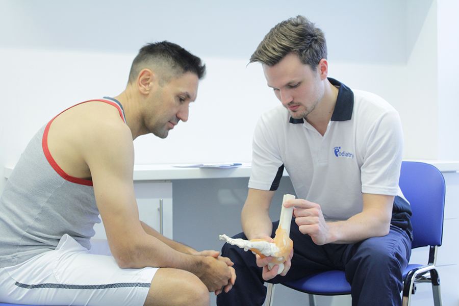Specialist showing patient the mechanics of the foot.