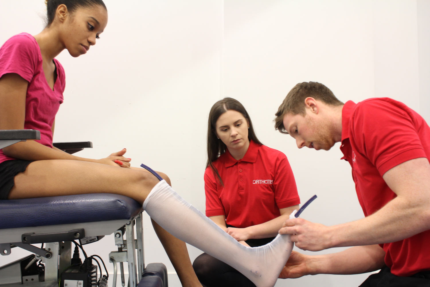 Pair of Orthotics professionals working with a young girl.