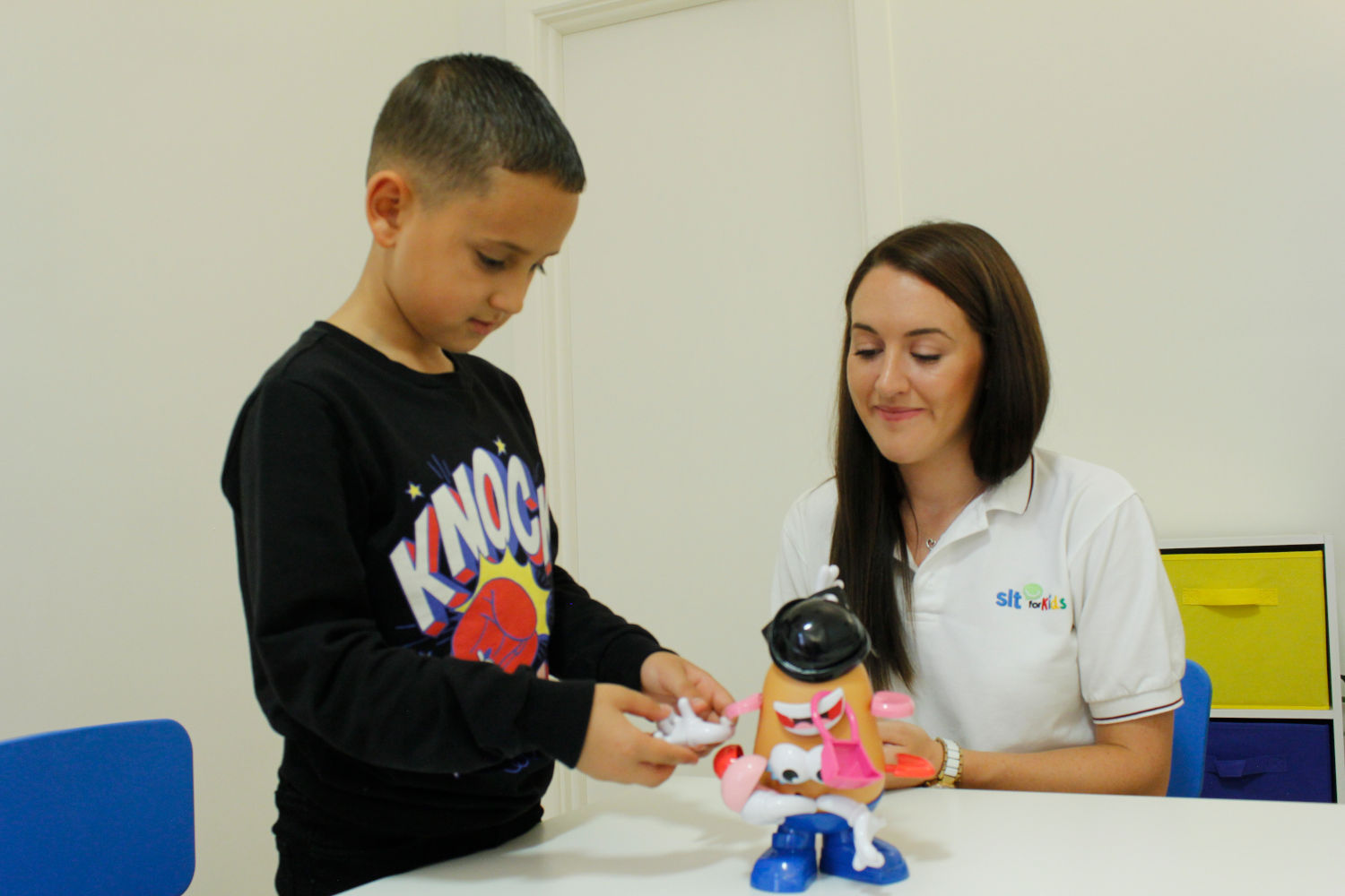 SLT for Kids therapist observing boy play with Mr. Potato Head.
